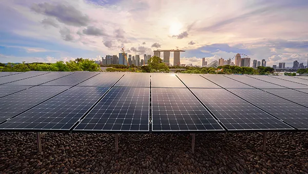 Solar panels with Singapore skyline in the background, symbolizing the semiconductor industry's shift toward green energy and sustainability.