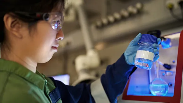 Scientist examining a sample in a lab, symbolizing research and innovation in the semiconductor ecosystem.