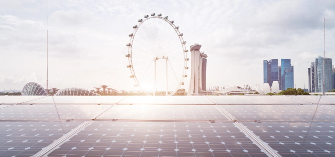 View of Singapore skyline featuring Marina Bay Sands and the Singapore Flyer, seen from a rooftop covered with solar panels, symbolizing clean energy and sustainability.
