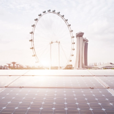 View of Singapore skyline featuring Marina Bay Sands and the Singapore Flyer, seen from a rooftop covered with solar panels, symbolizing clean energy and sustainability.