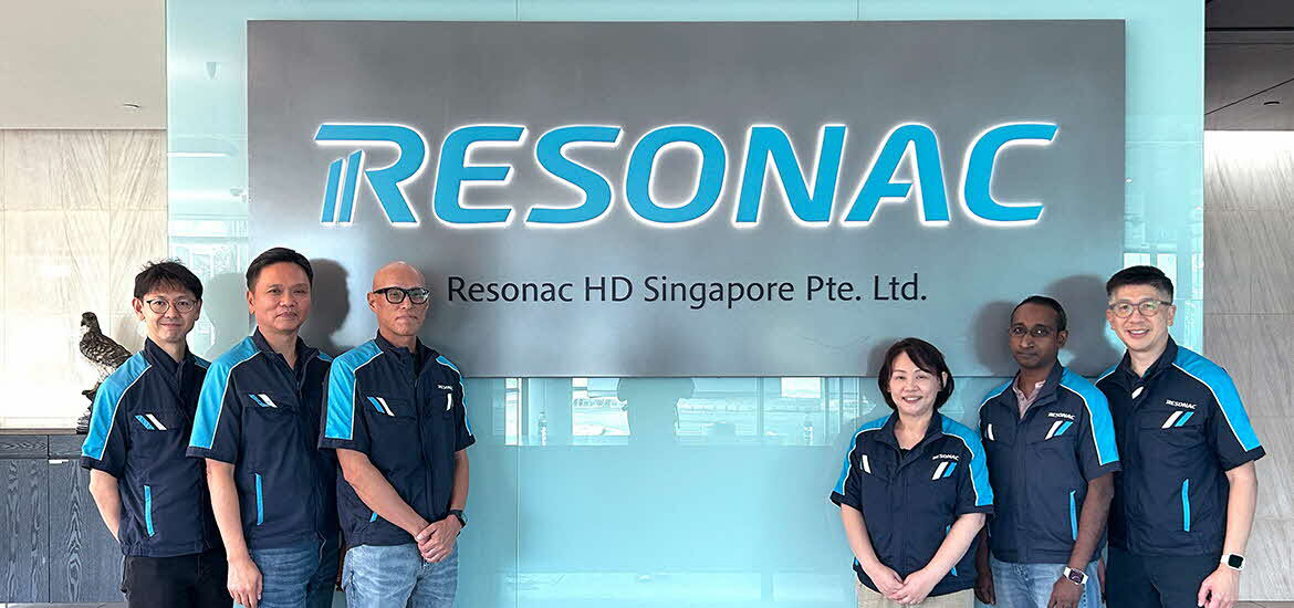 Team members from Resonac HD Singapore posing in front of the company’s corporate sign, representing a diverse workforce at the semiconductor materials and advanced manufacturing facility.
