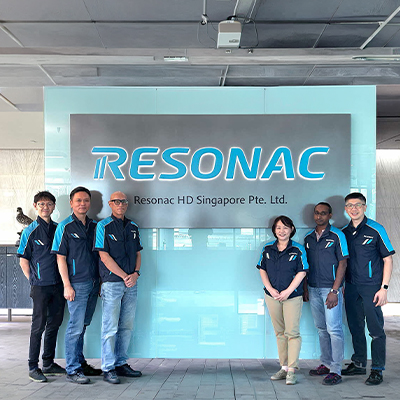 Team members from Resonac HD Singapore posing in front of the company’s corporate sign, representing a diverse workforce at the semiconductor materials and advanced manufacturing facility.