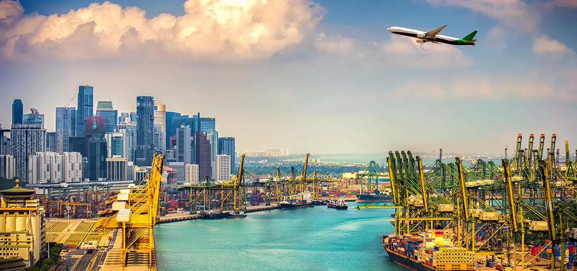 Aerial view of Singapore's city skyline with high-rise buildings, bustling port with container cranes, and an airplane flying overhead under a vibrant sky.