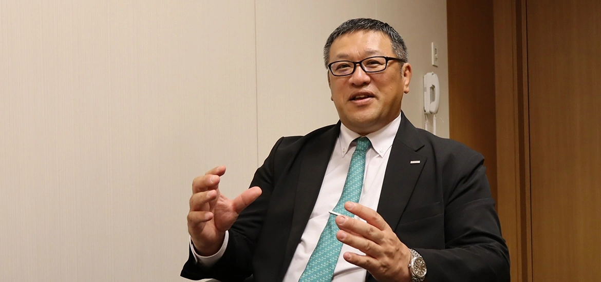 Man in a suit speaking during an interview.