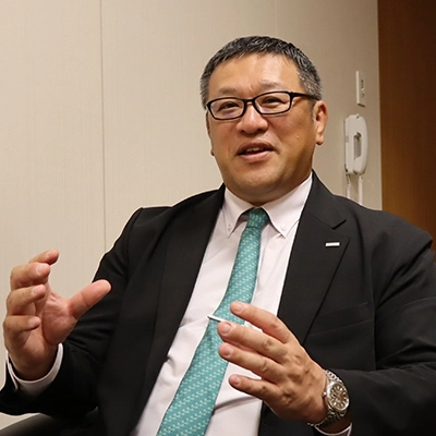 Man in a suit speaking during an interview.