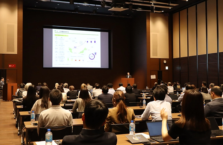 Audience attending a presentation in a conference hall.
