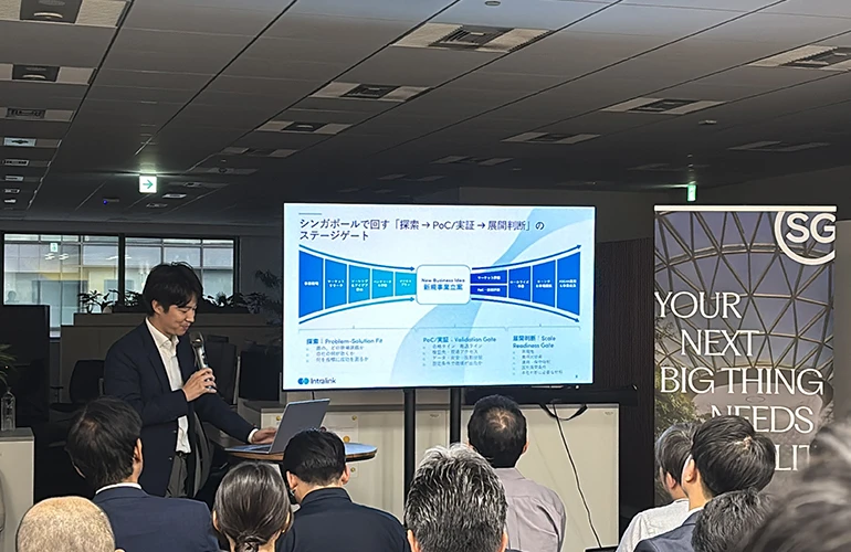 Speaker presenting to an audience at a Japanese event on Singapore’s Physical AI industry.