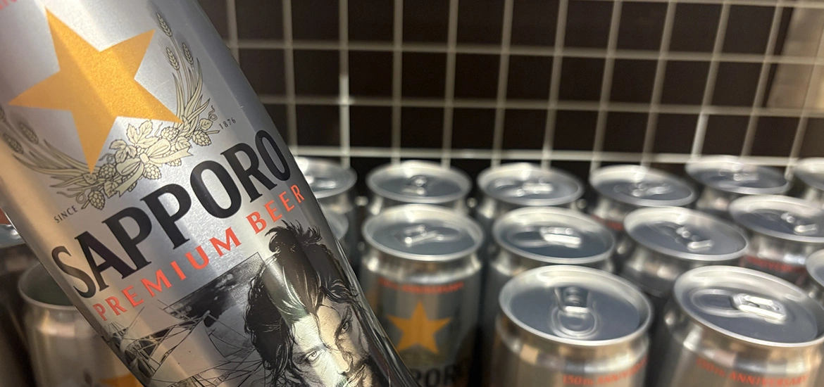 Close-up of a Sapporo Premium Beer can with more cans in the background.