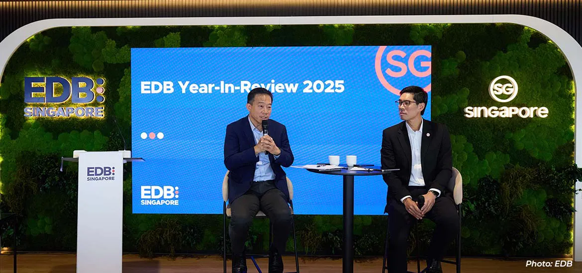 Two speakers seated on stage during the EDB Year-in-Review 2025 event, with a large screen backdrop and EDB Singapore branding.
