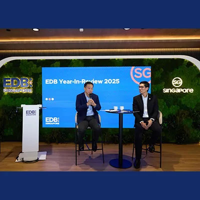 Two speakers seated on stage during the EDB Year-in-Review 2025 event, with a large screen backdrop and EDB Singapore branding.