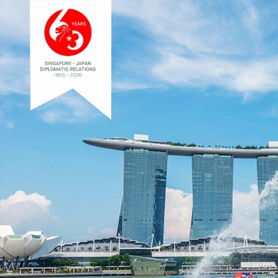 The Merlion statue in Singapore spouting water with Marina Bay Sands in the background, alongside a “60 Years Singapore–Japan Diplomatic Relations (1966–2026)” emblem.