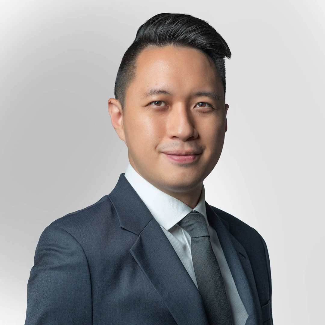 Portrait of a man in a suit and tie against a plain background, with a slight smile.